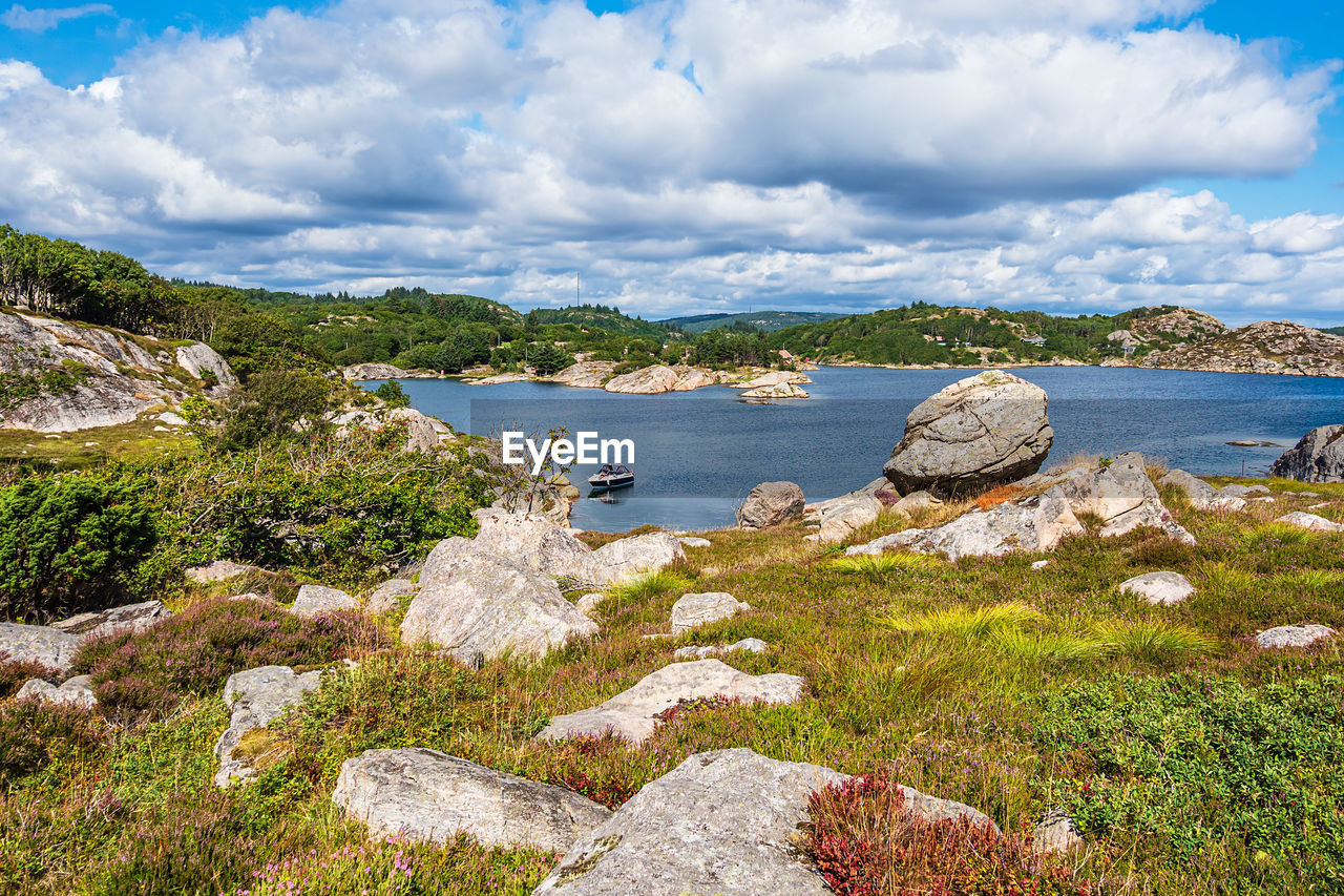 SCENIC VIEW OF SEA AGAINST ROCKS AND TREES AGAINST SKY