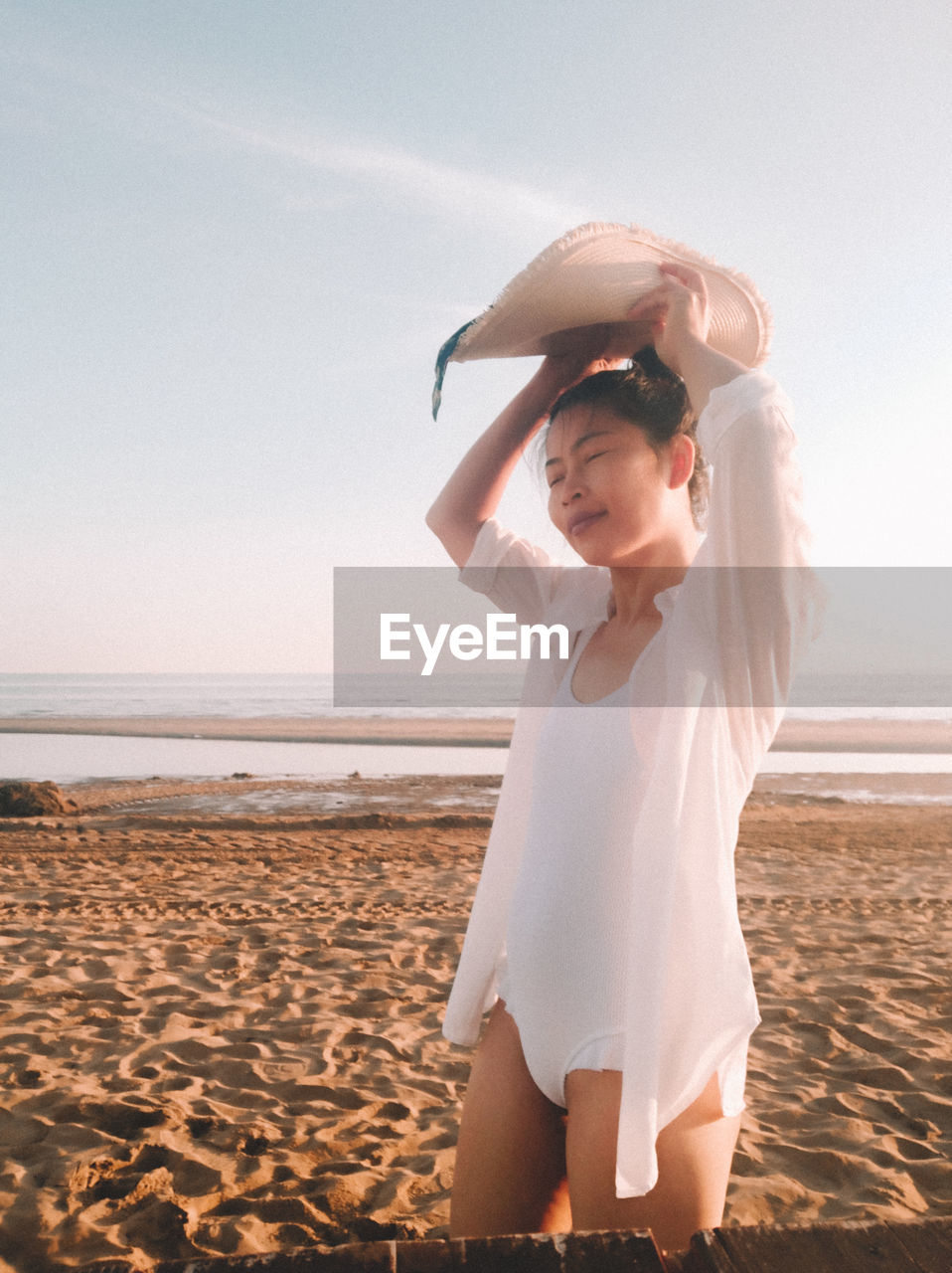 WOMAN STANDING AT BEACH