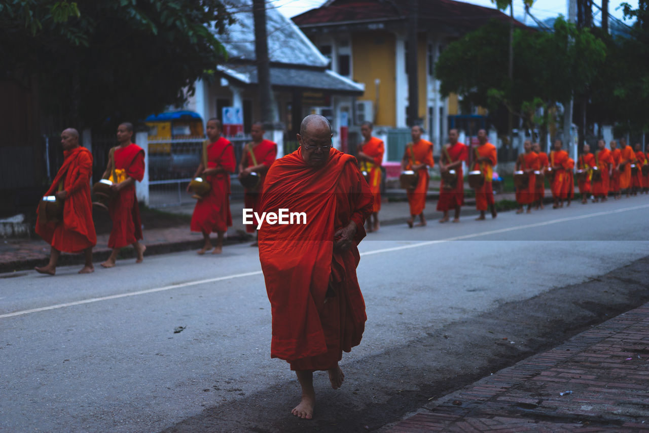 REAR VIEW OF PEOPLE WALKING ON TEMPLE