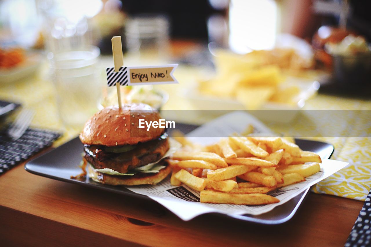 High angle view of french fries and hamburger served on table