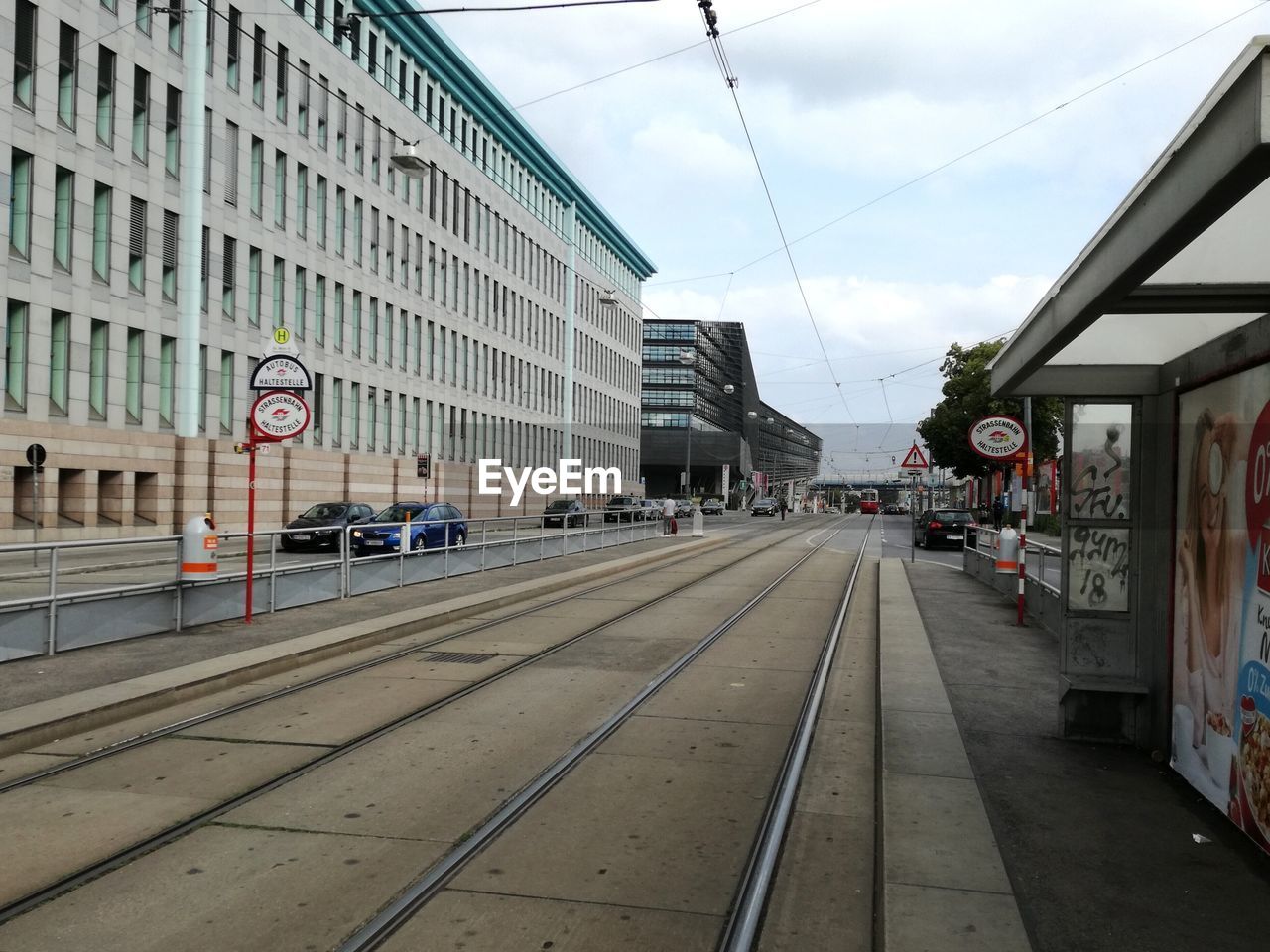 RAILROAD TRACKS BY BUILDINGS AGAINST SKY