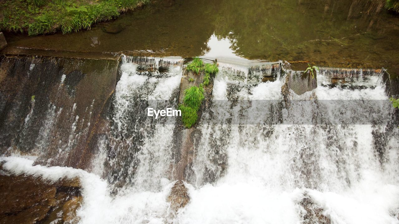 Scenic view of water falling from dam