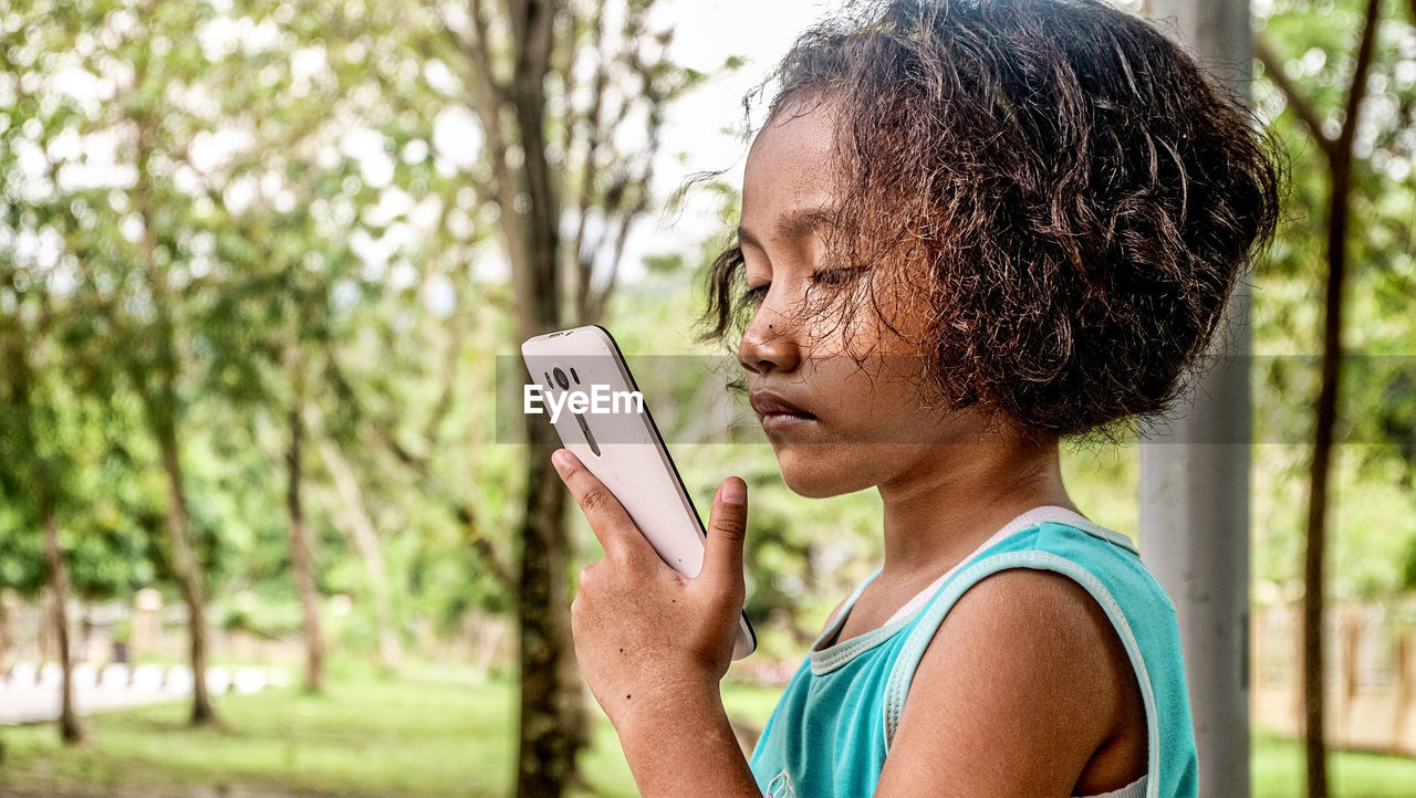 Side view of girl using mobile phone