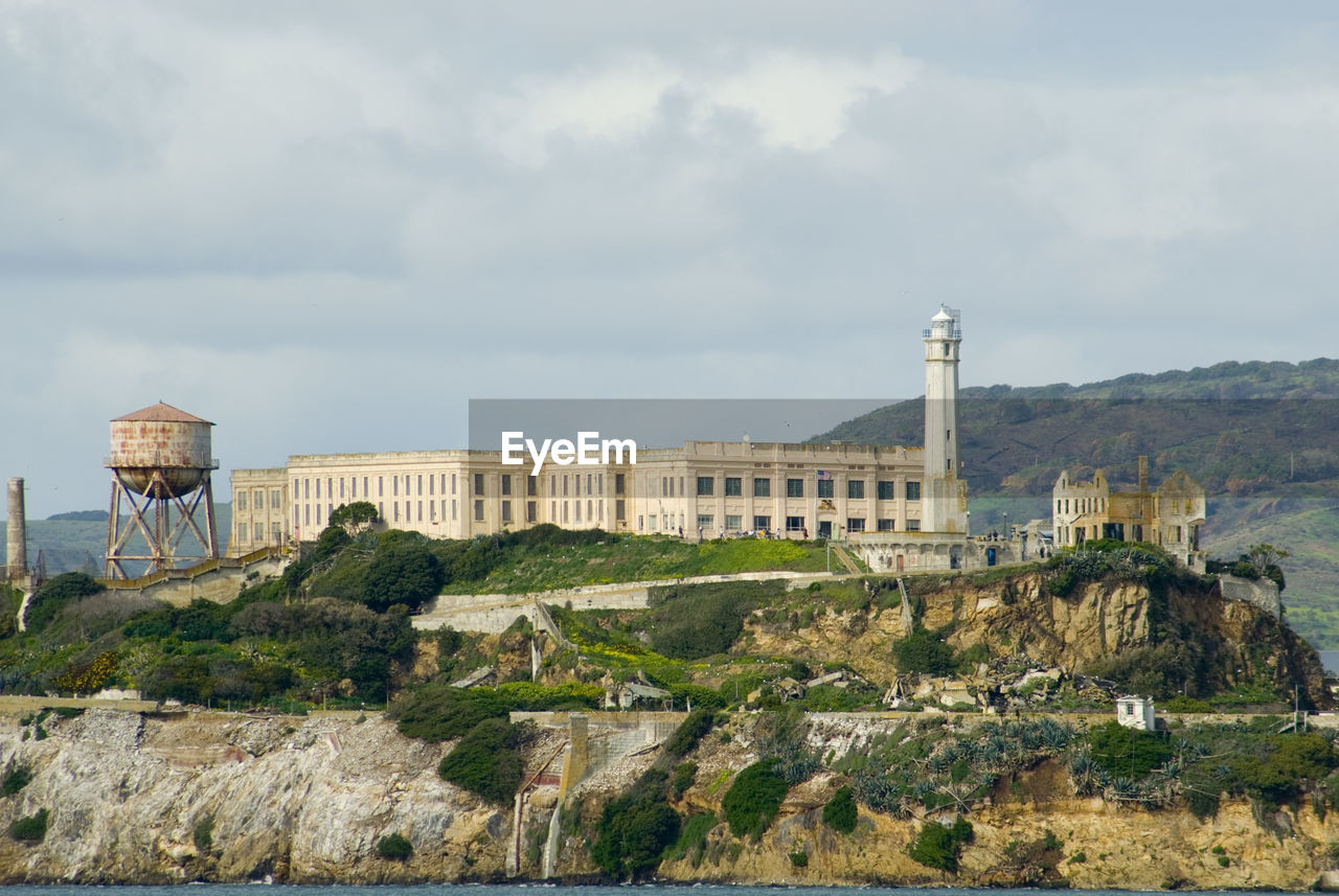 Lighthouse by prison at alcatraz island against sky