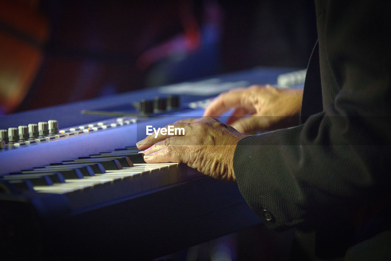 Midsection of man playing piano 