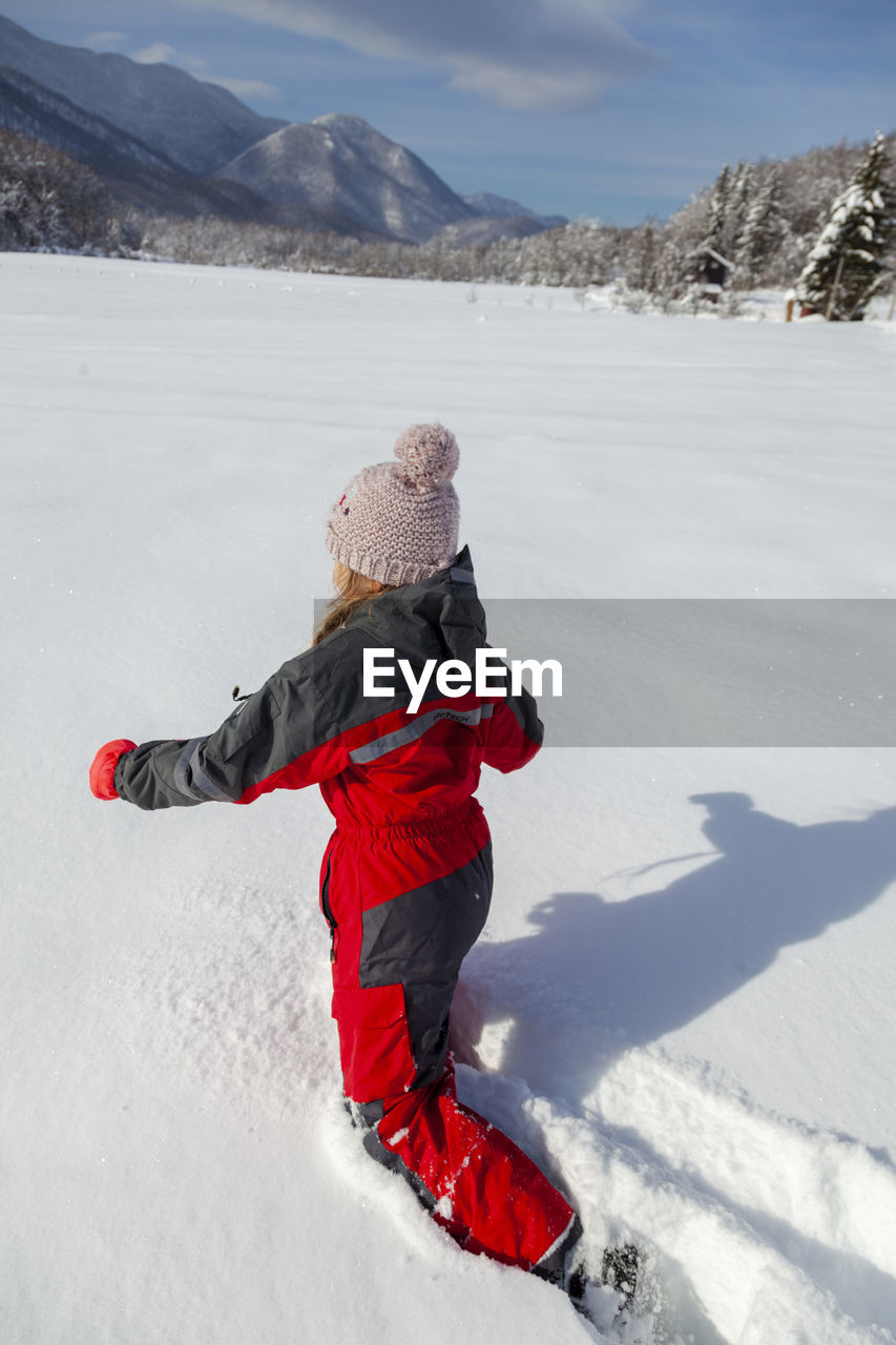 Young girl is having winter fun on a snowy, sunny day in lika, croatia