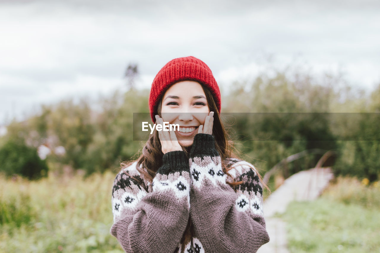 PORTRAIT OF SMILING YOUNG WOMAN IN WINTER