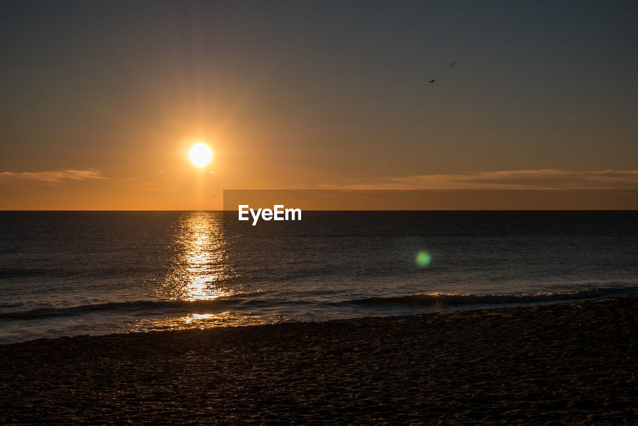 SCENIC VIEW OF SUNSET OVER SEA