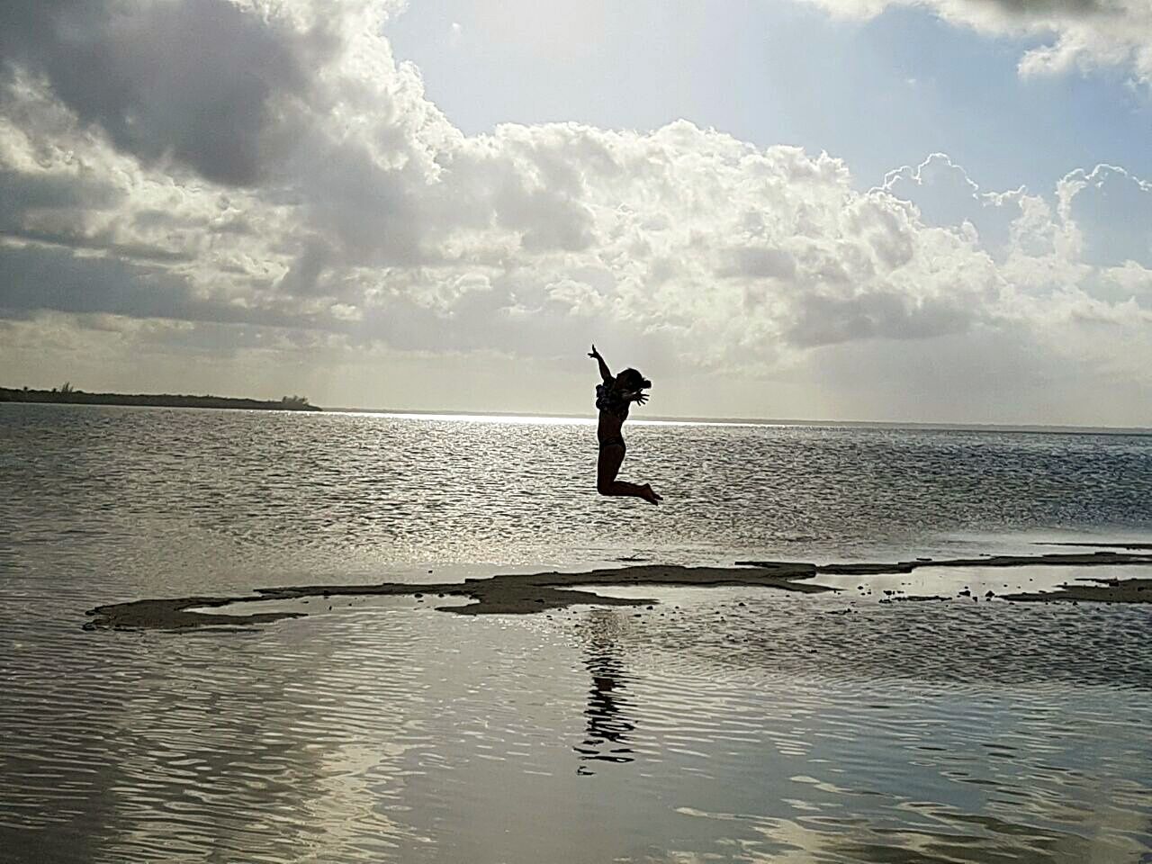 MAN STANDING ON SHORE AGAINST SKY