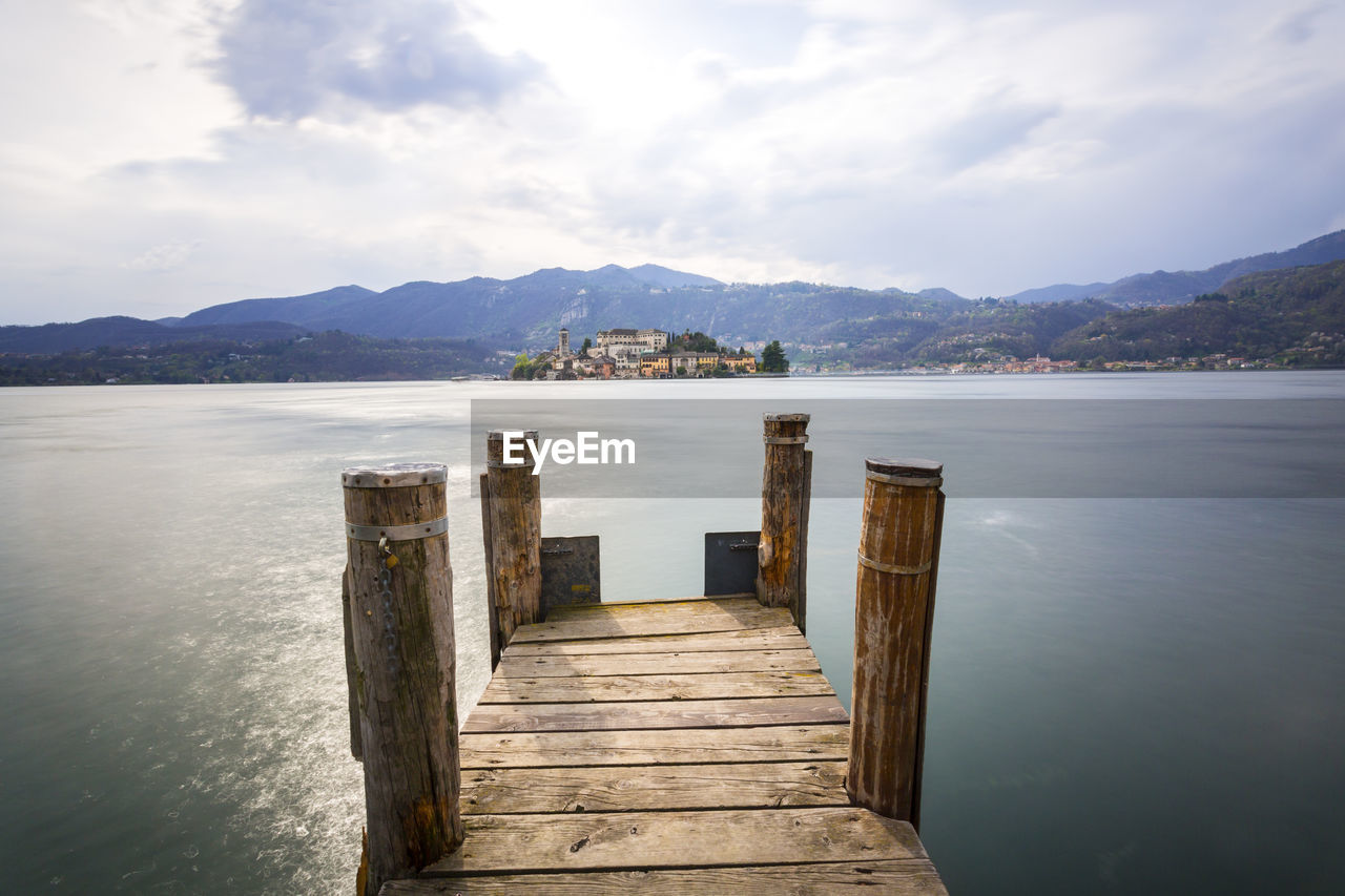 PIER ON SEA BY MOUNTAINS AGAINST SKY