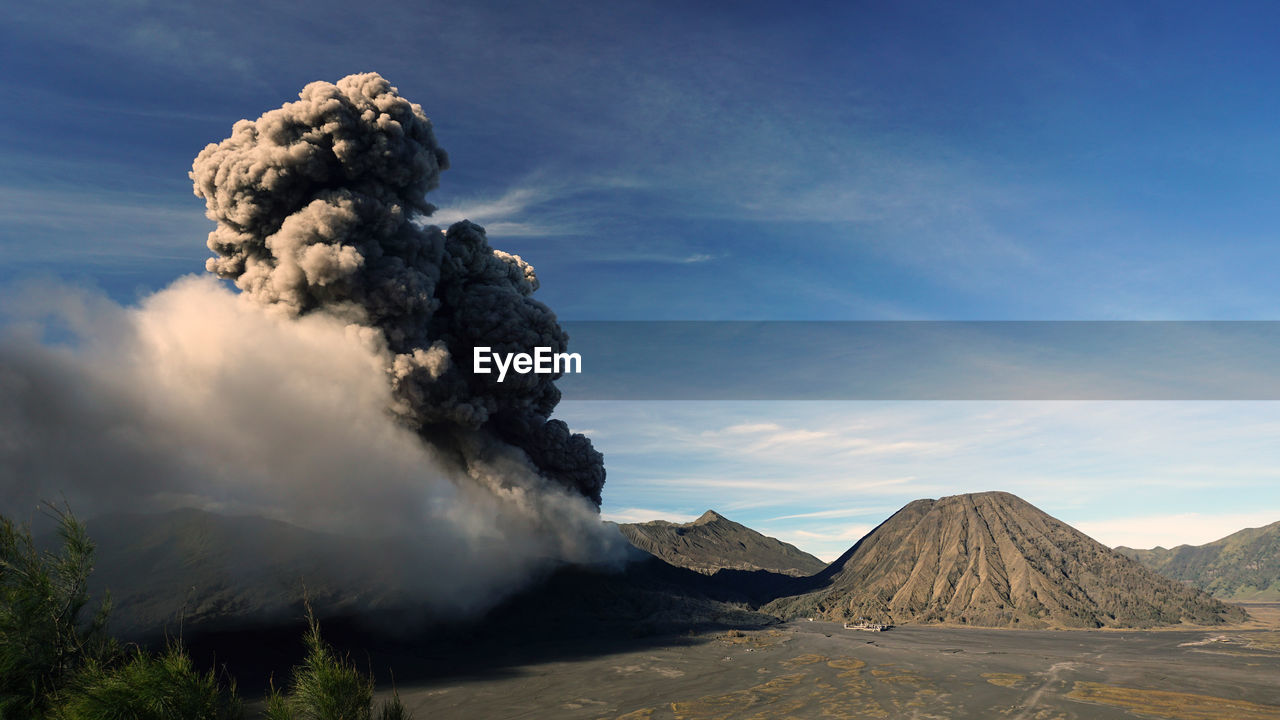 SMOKE EMITTING FROM VOLCANIC MOUNTAINS AGAINST SKY