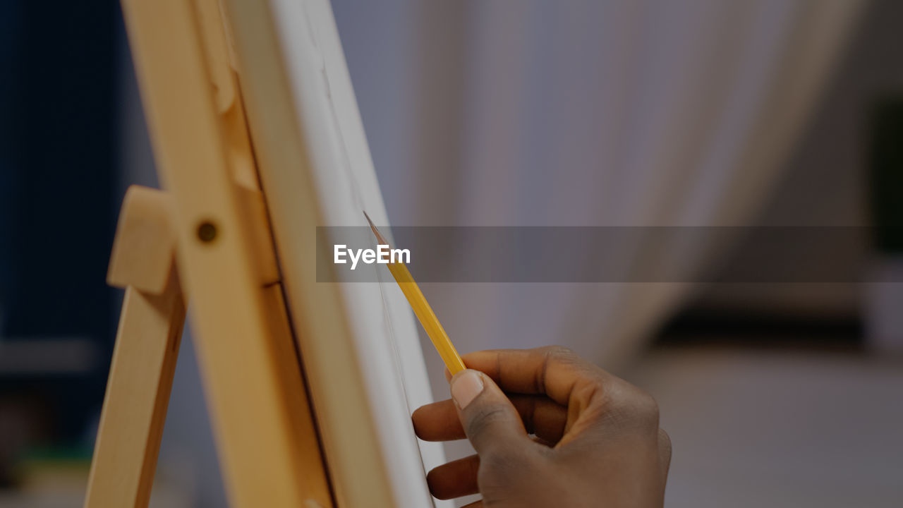 cropped hand of woman holding pencil