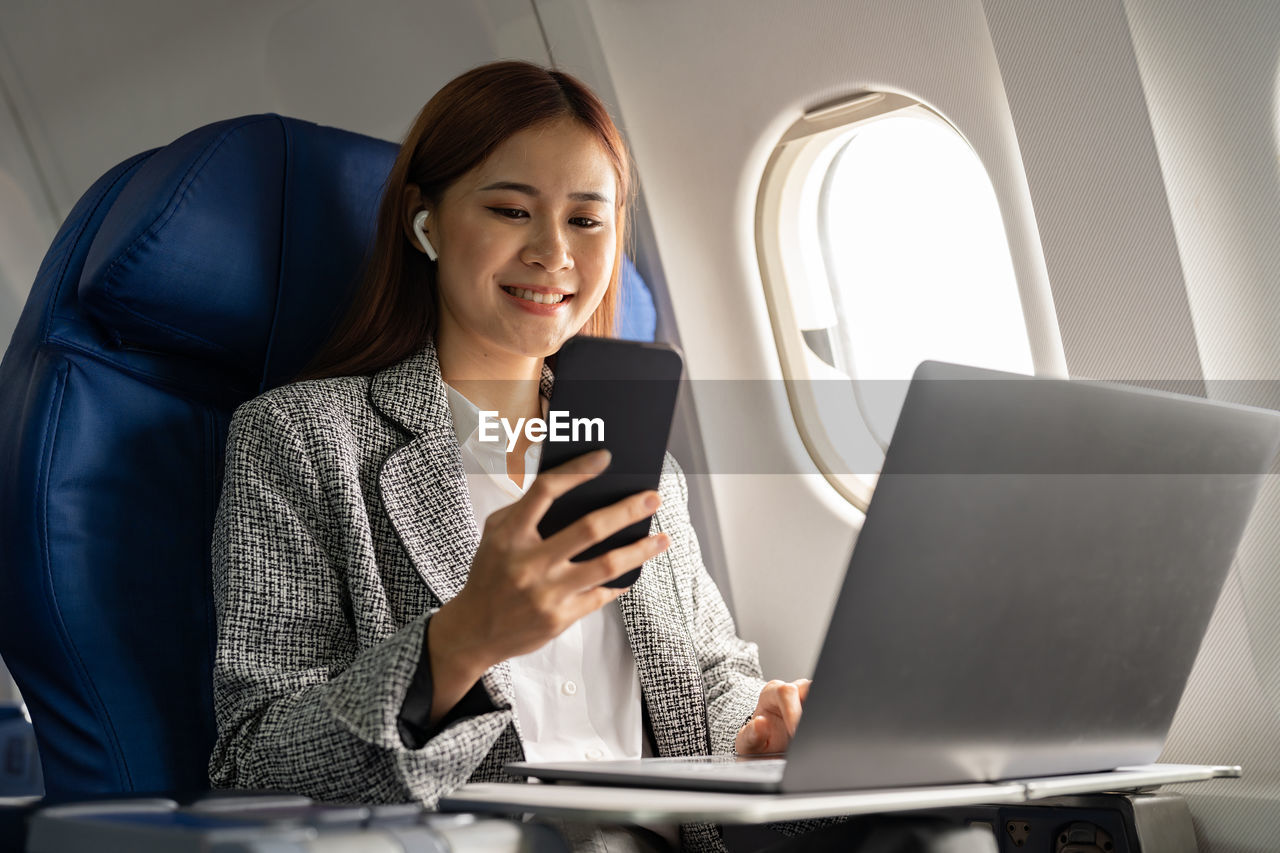 young businesswoman using laptop while sitting on sofa