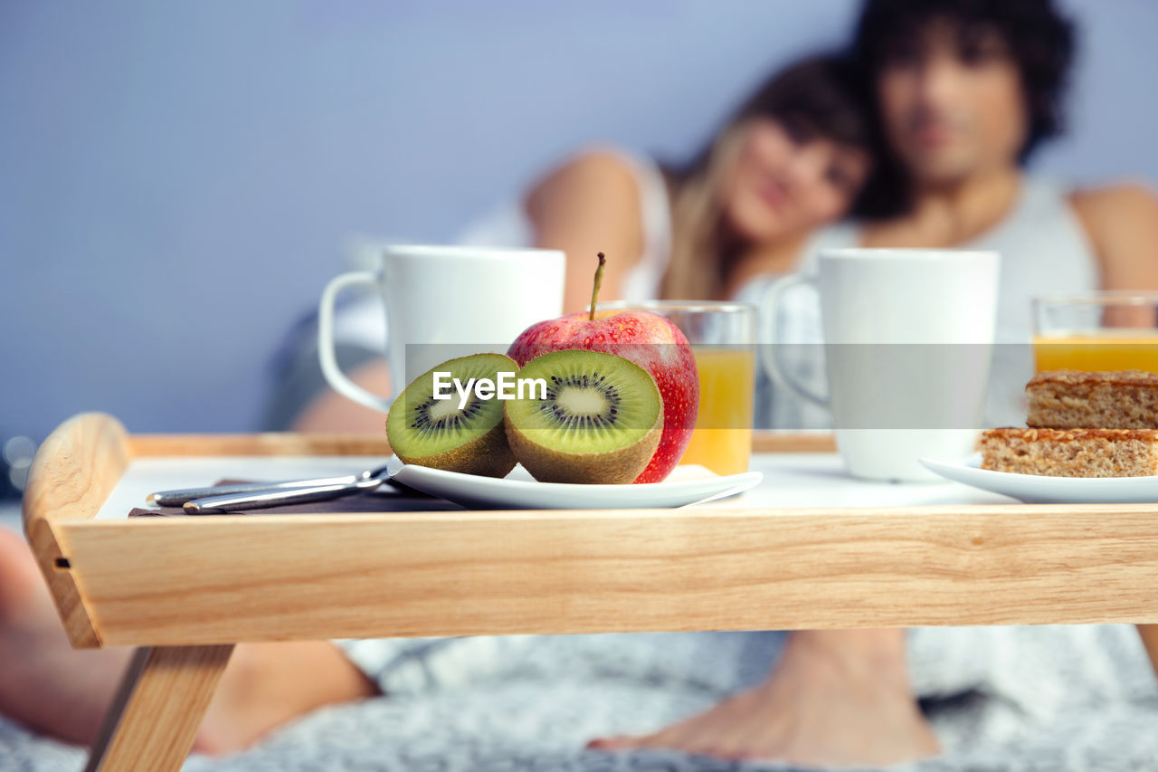 Couple with breakfast on bed at home