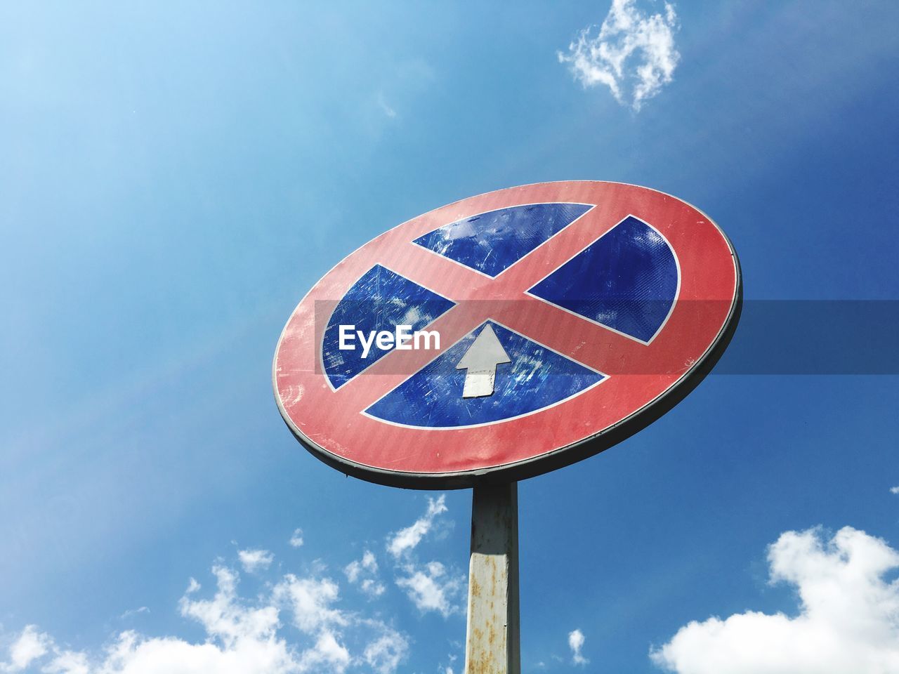 Low angle view of sign against blue sky