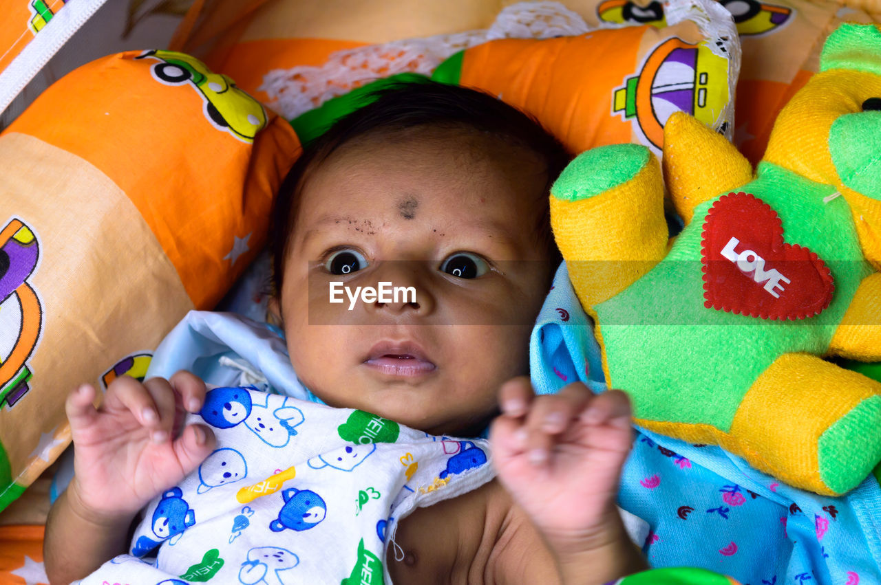 Close up portrait of cute newborn baby looking at camera. indian ethnicity. high angel view.