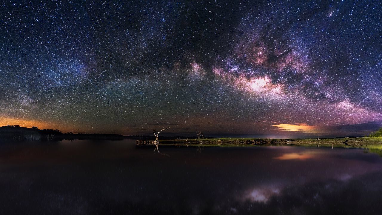 Scenic view of lake against sky at night