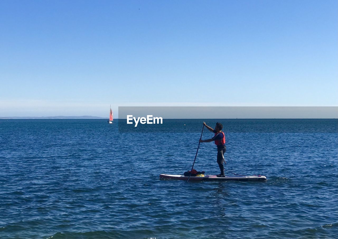 MAN ON SEA AGAINST CLEAR SKY