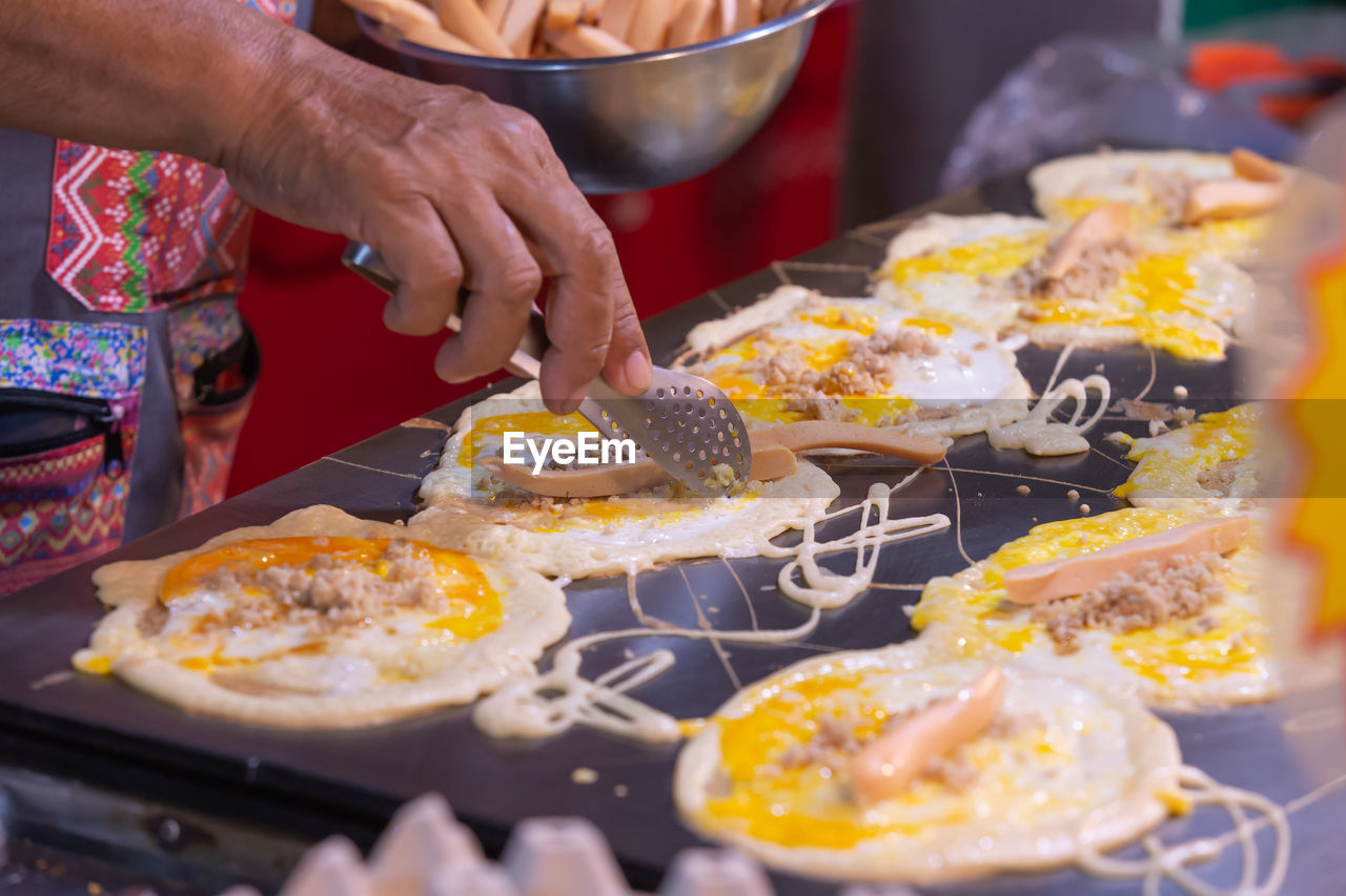HIGH ANGLE VIEW OF MAN PREPARING FOOD ON TABLE