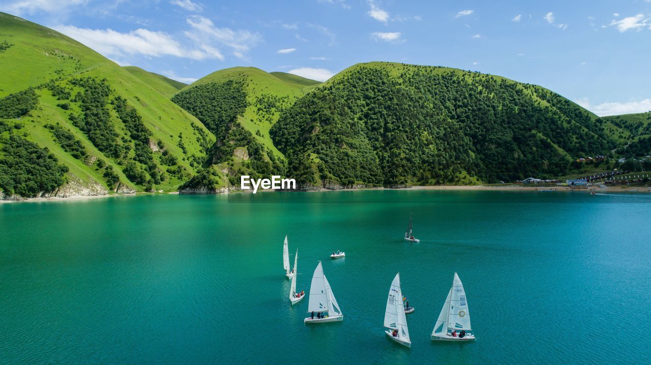 SAILBOAT IN LAKE AGAINST SKY