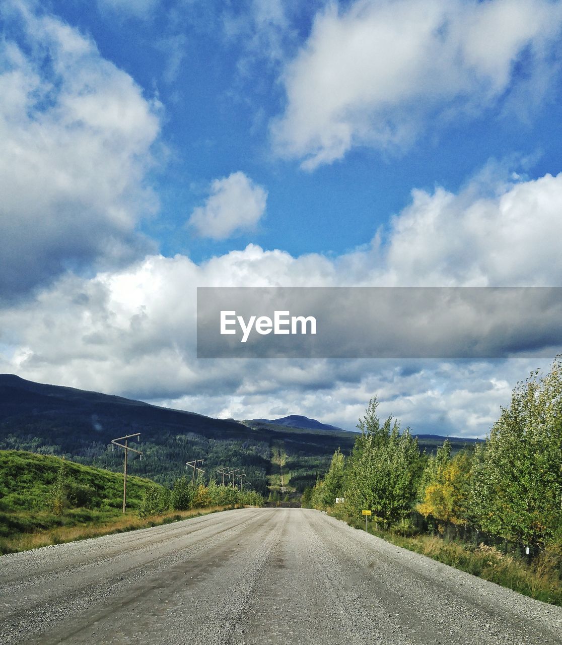 Empty road along landscape against sky