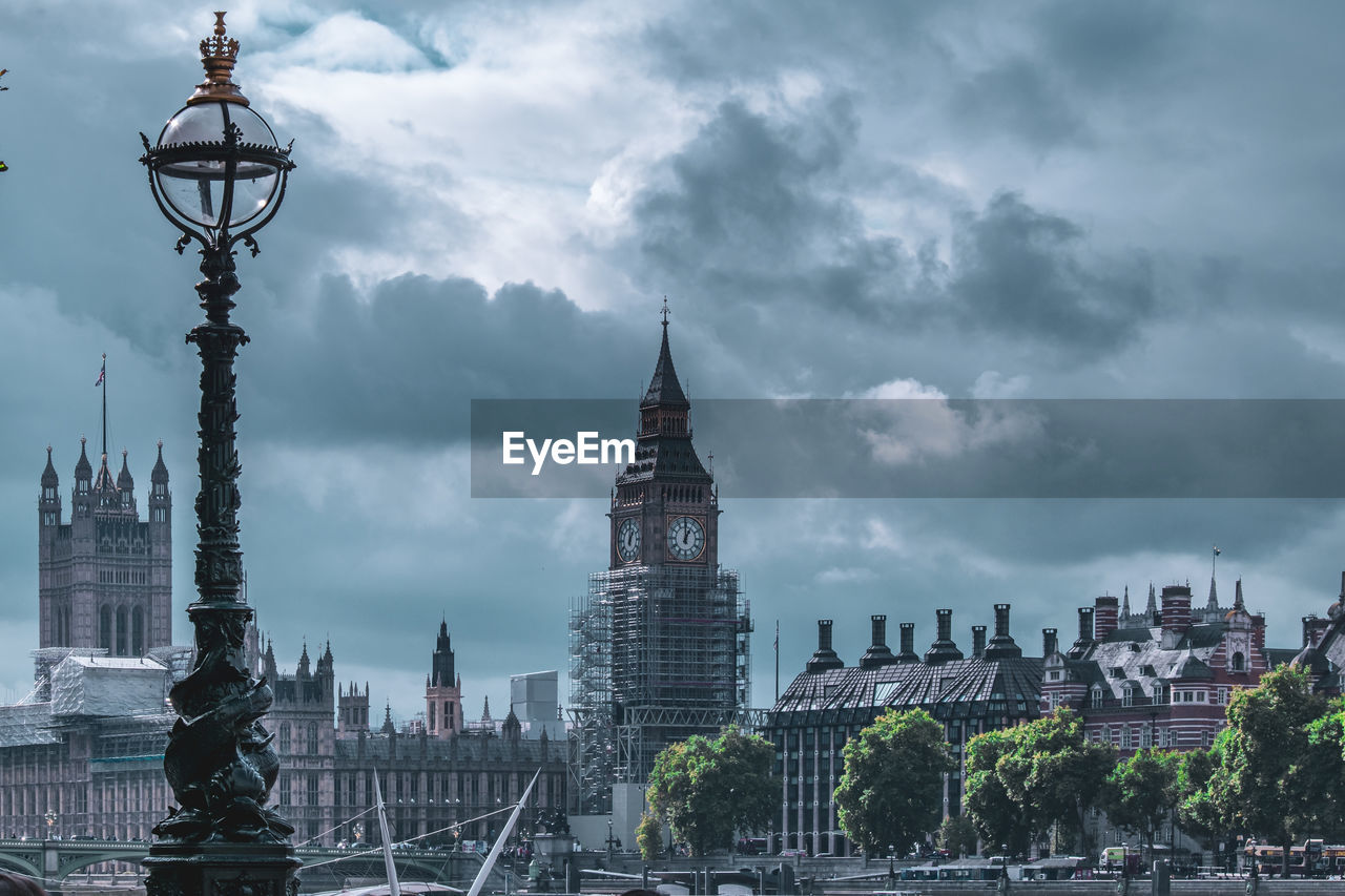 Buildings in city against cloudy sky