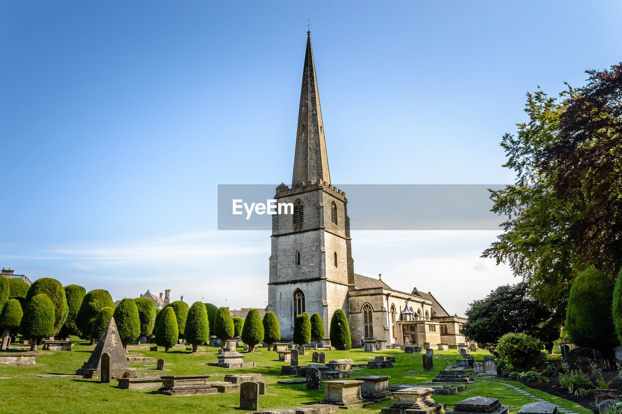 Low angle view of st mary church with cemetery in foreground at painswick