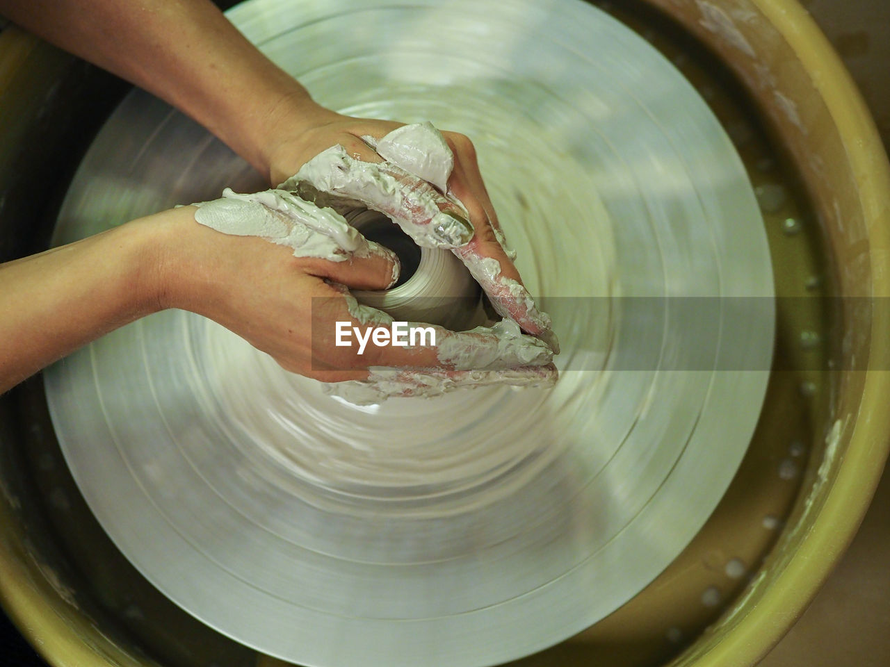 Cropped hand of person working with pottery