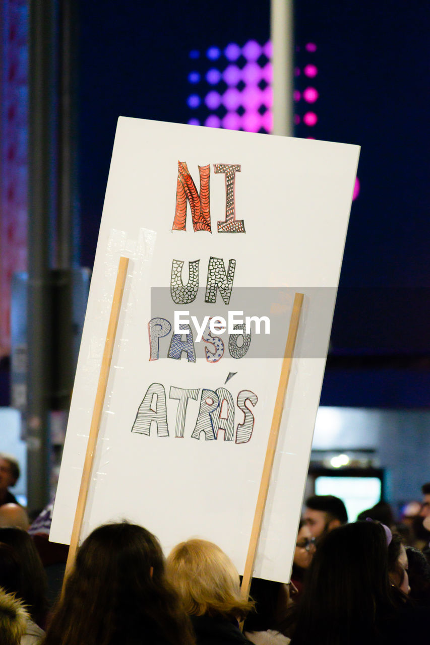 People holding placards with text during protest at night