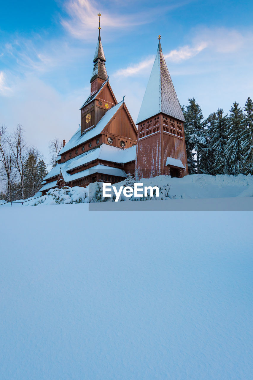 CHURCH ON FIELD BY BUILDING AGAINST SKY