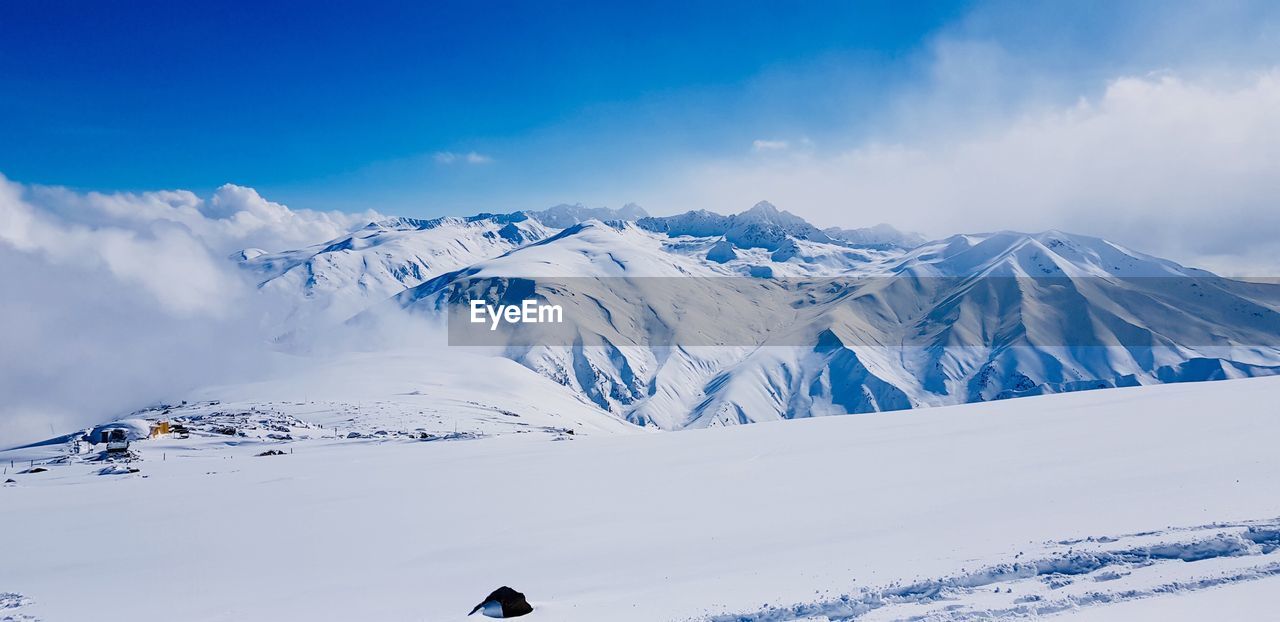 Scenic view of snow covered mountains against sky