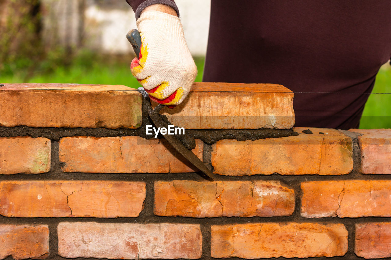 brick, one person, wall, brick wall, adult, architecture, men, brickwork, wood, outdoors, day, hand, lifestyles, nature