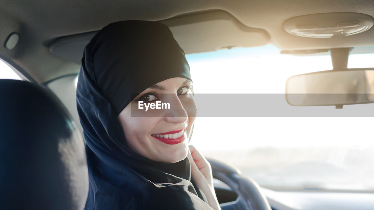 PORTRAIT OF A SMILING WOMAN IN CAR