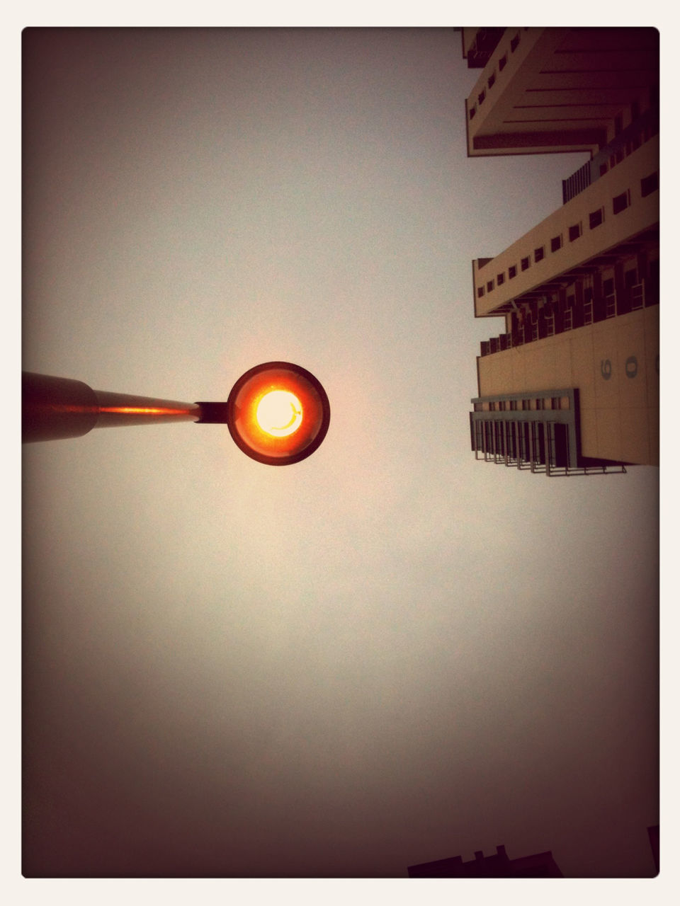 Directly below shot of street light and building against clear sky