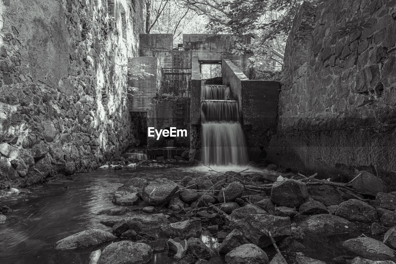 WATER FLOWING THROUGH ROCKS ON BUILDING