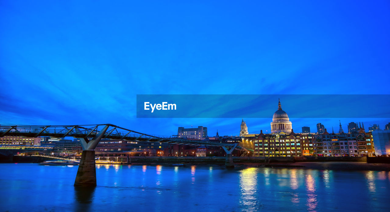 VIEW OF ILLUMINATED CITYSCAPE AGAINST BLUE SKY