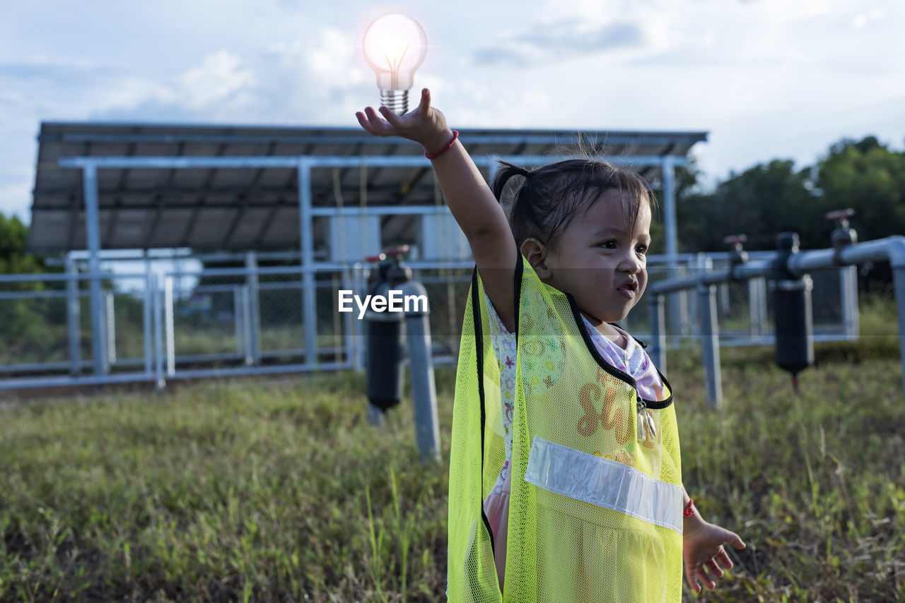 Young women and the future of renewable energy sustainable energy hold the bulb to the solar panel.