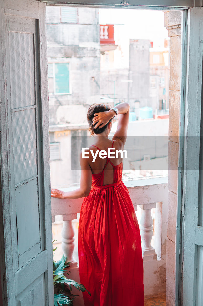 Rear view of woman photographing through window