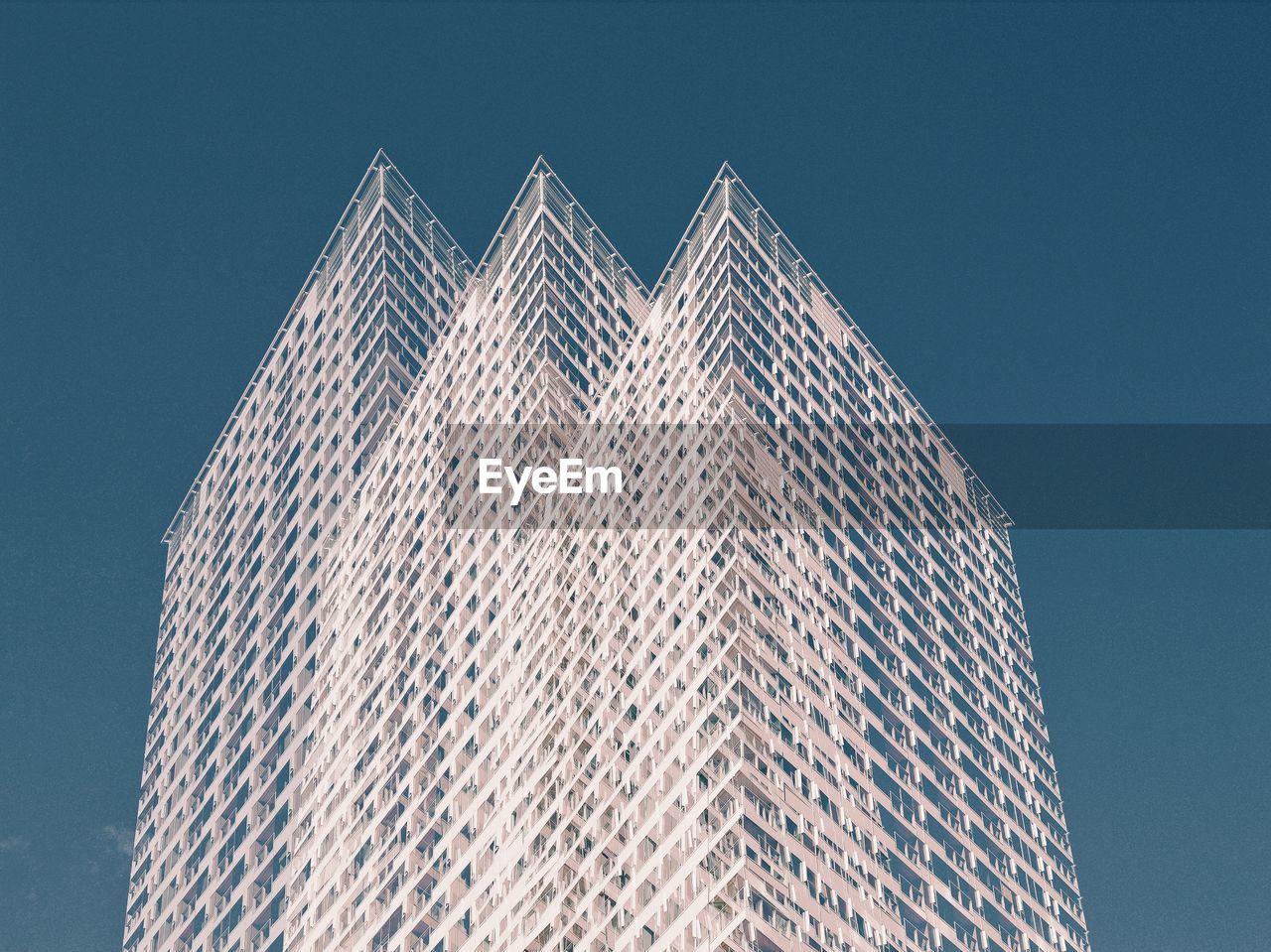 Low angle view of modern building against clear blue sky