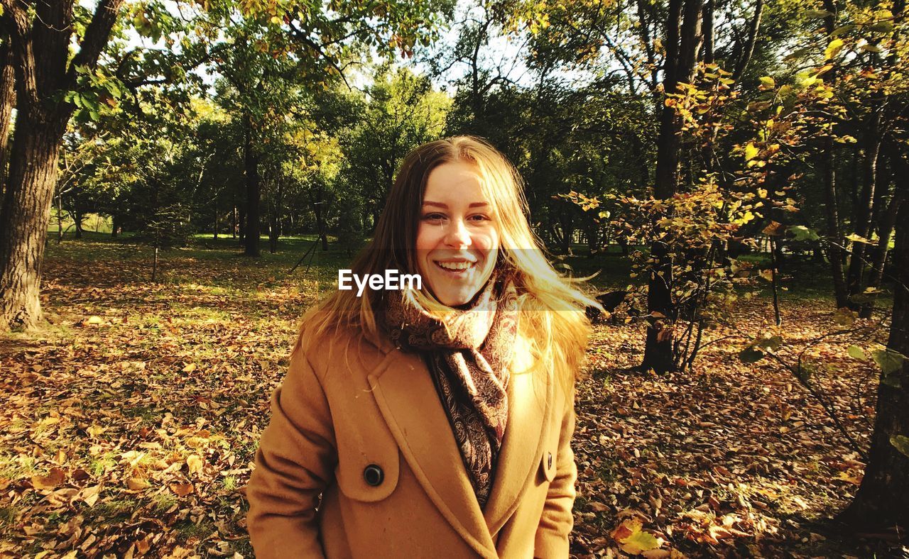 Portrait of smiling young woman standing in park