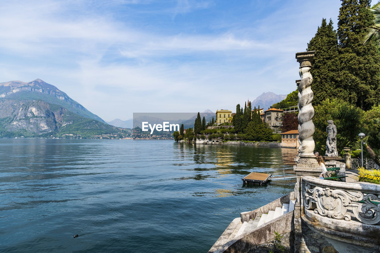 Scenic view of lake against mountains and cloudy sky