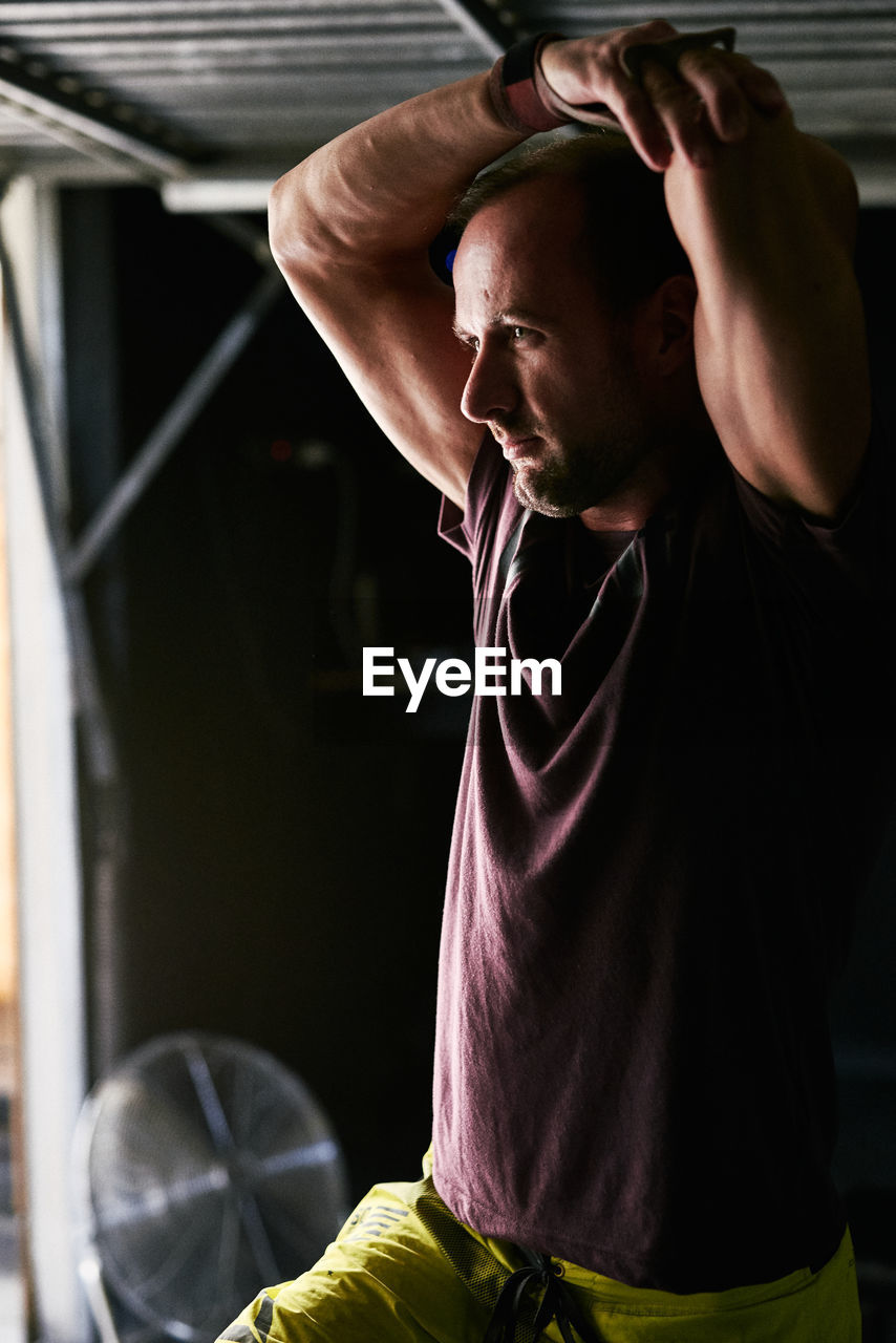 Fit young man stretching in a garage