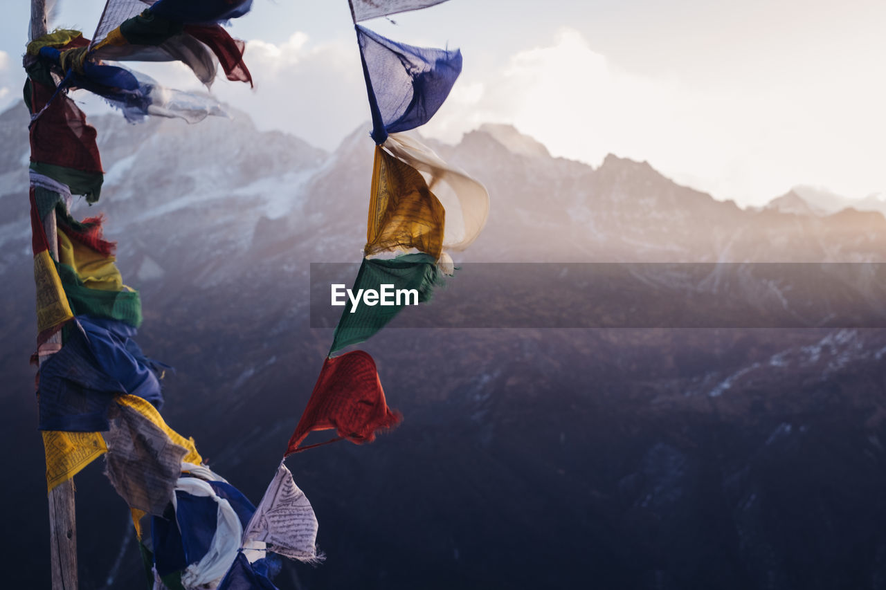 Close-up of flag on mountain range against sky