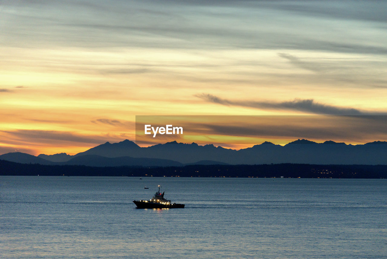 Ship at sunset over puget sound and the olympic mountains.