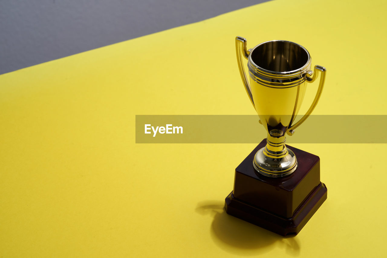 Close up of trophy on yellow background