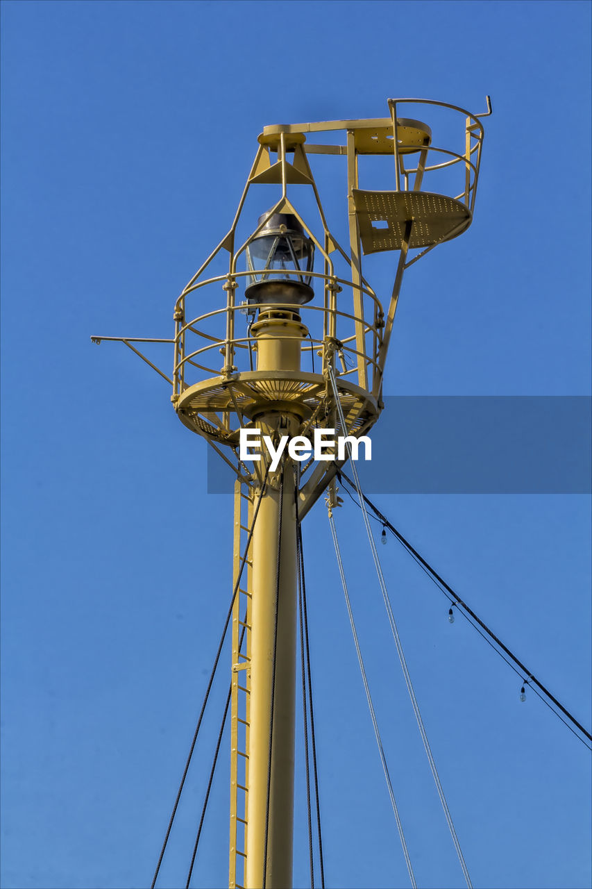 High section of electricity pole against clear blue sky