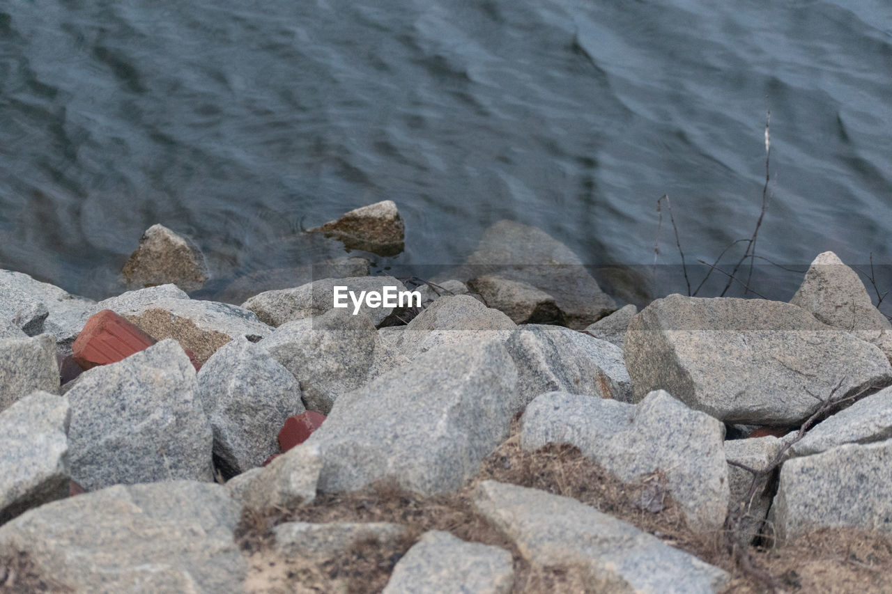 CLOSE-UP OF ROCKS ON BEACH