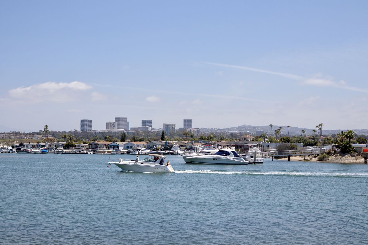 BOATS IN SEA AGAINST CITY BUILDINGS