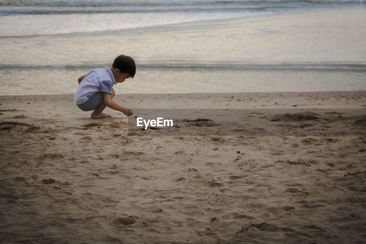 Boy playing in sand at beach