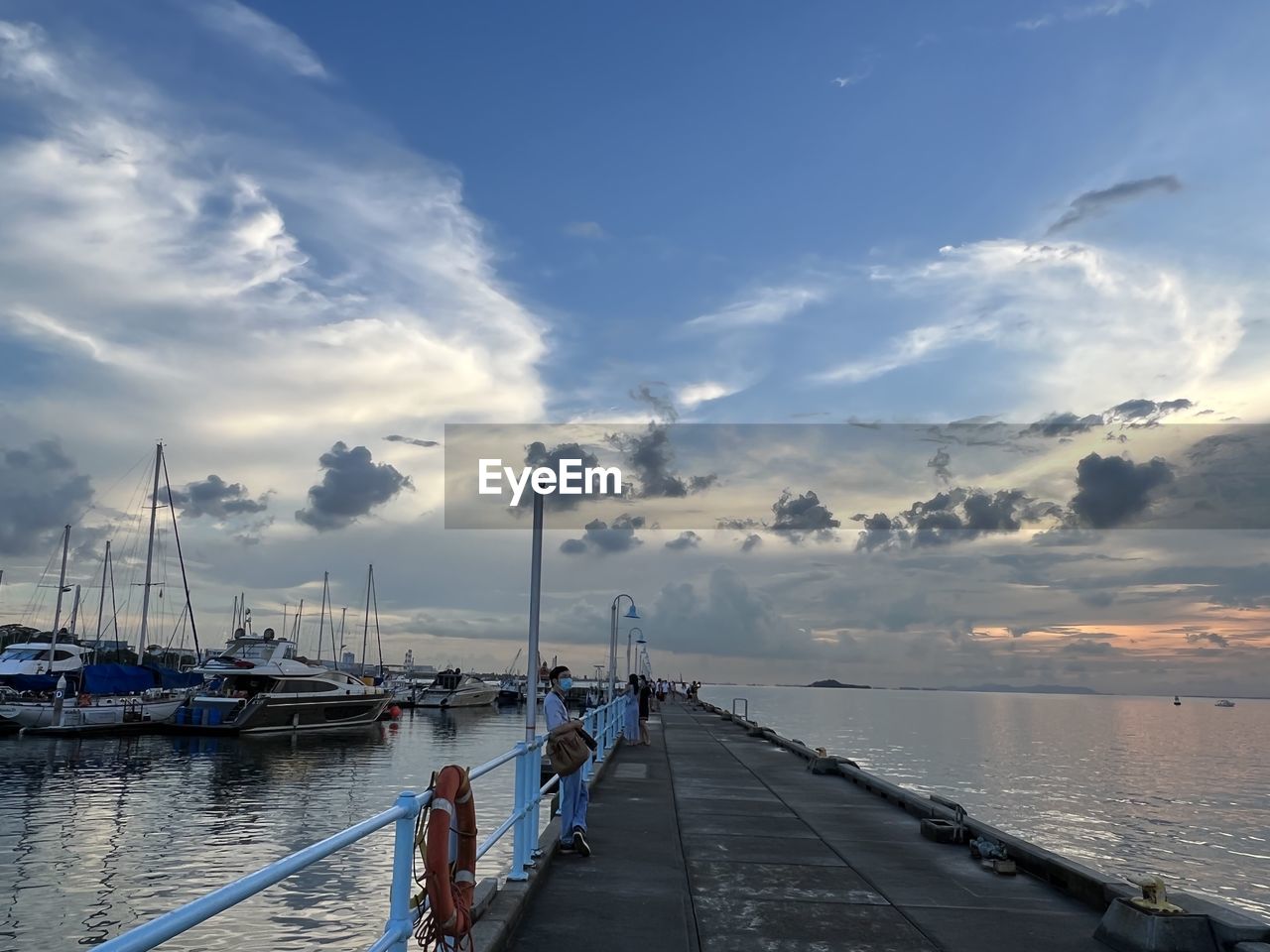 SAILBOATS MOORED AT HARBOR AGAINST SKY